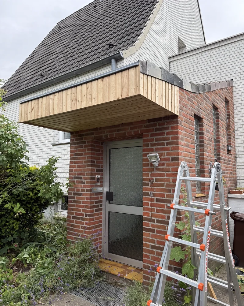 Vordach während der Montage, die Leiter steht noch am Klinkermauerwerk