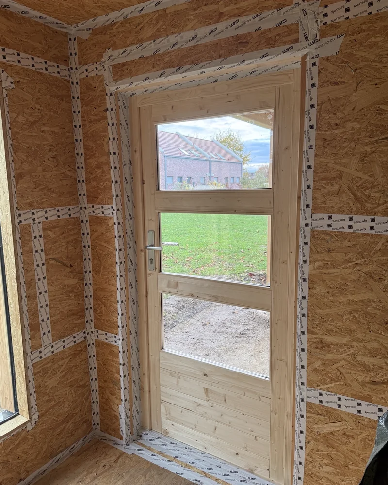 Eingesetzte Holztür mit Glasfeld in einem mit OSB beplankten Gartenhaus